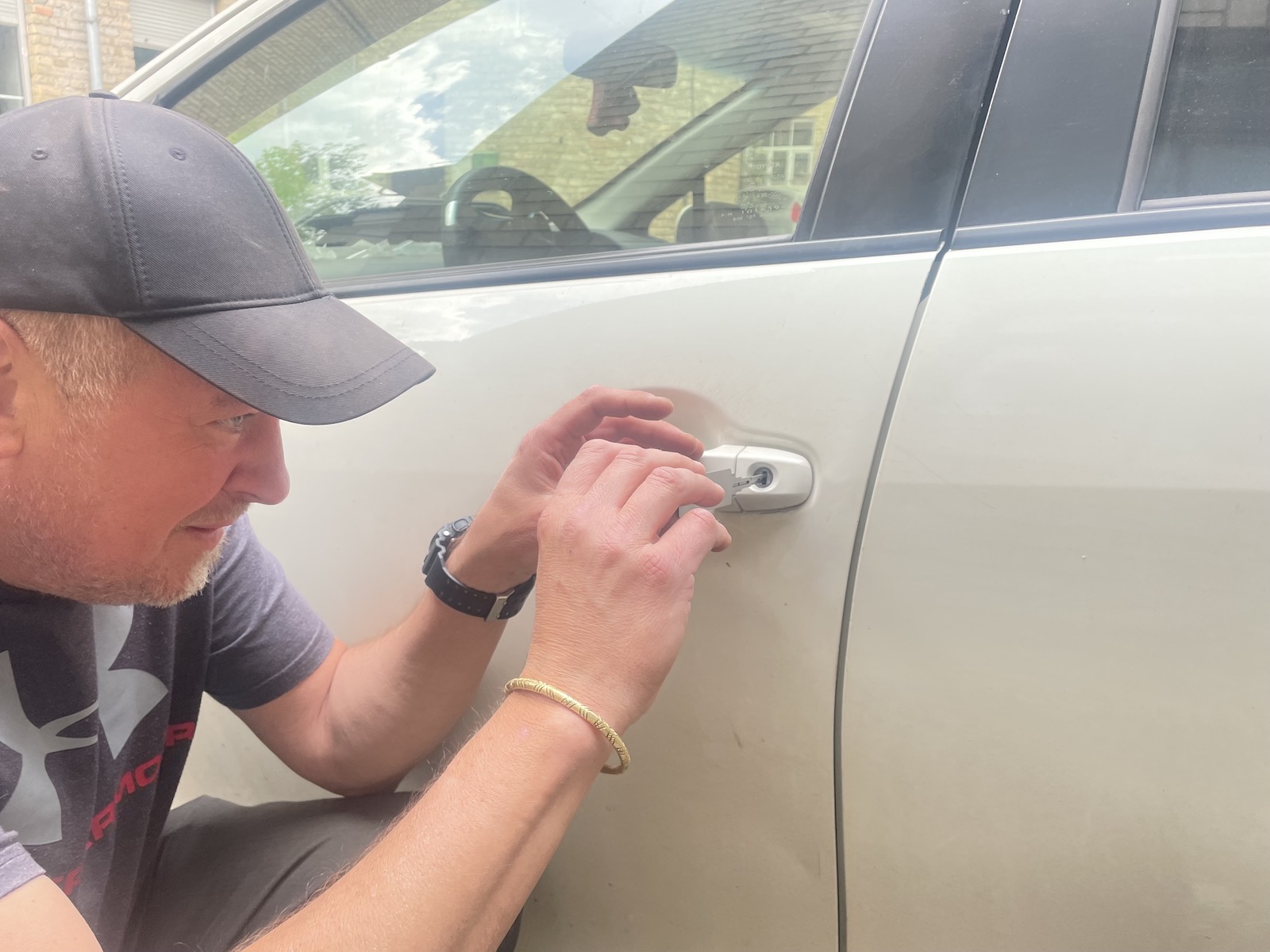 Meistras atrakinėja balto Toyota Prius automobilio duris