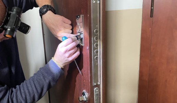 Meistras remontuoja šarvuotų durų spyną